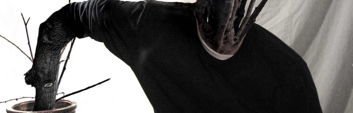 Image of tree branches emerging from the arms and neck of a man's top