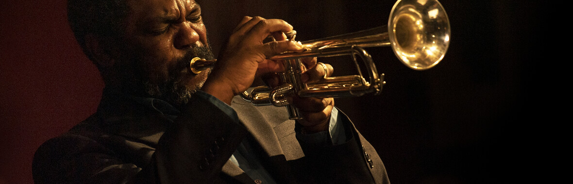 Byron Wallen playing trumpet with a black background