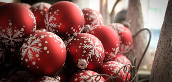 A bowl full of red Christmas Baubles.