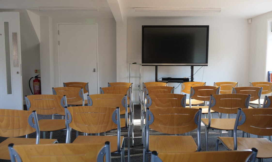 Chairs set up in rows facing a monitor.